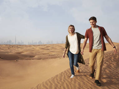 Stel in de woestijn met Dubai op de achtergrond